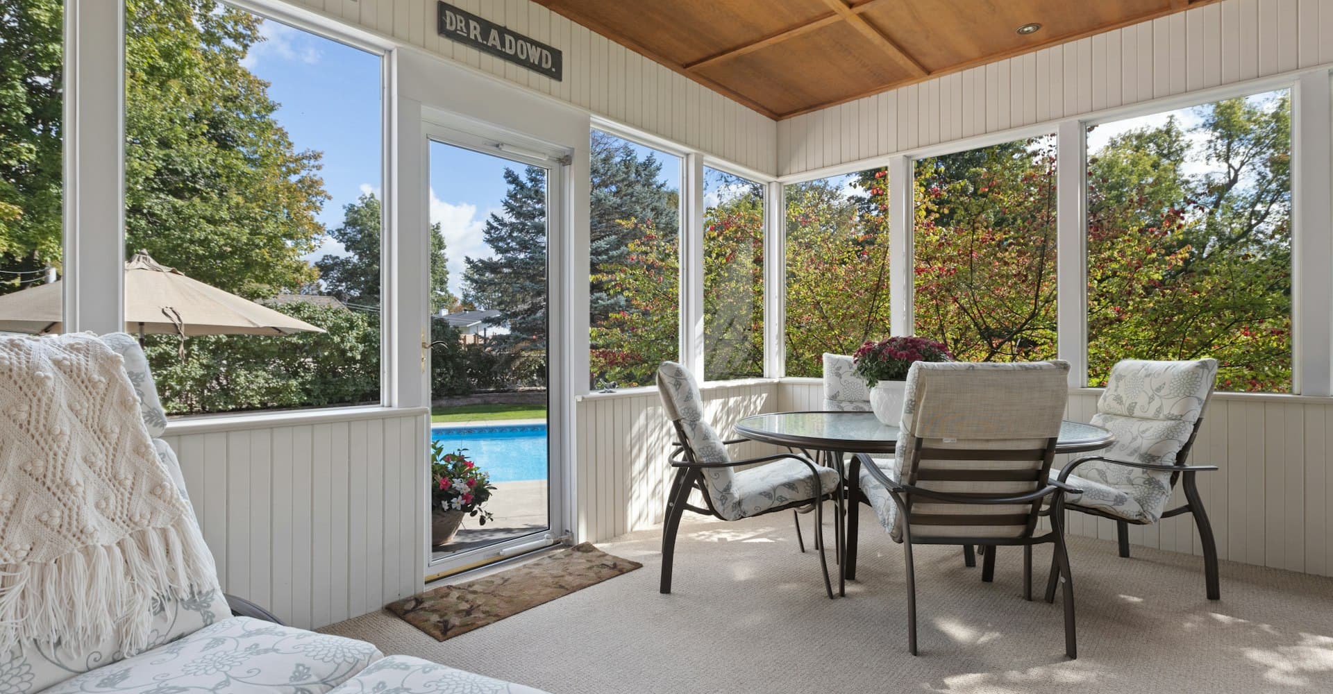 Screened, covered patio with a wood ceiling overlooking a pool